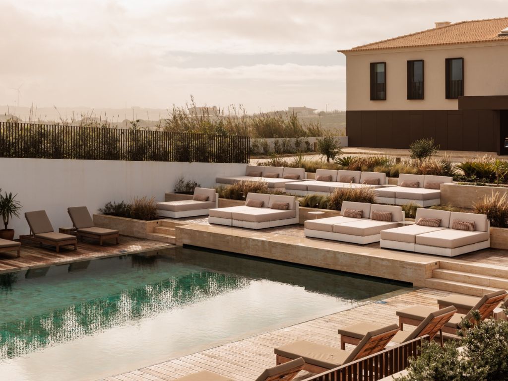 A luxurious pool desk with sun loungers and cabana beds at Aethos Ericeira