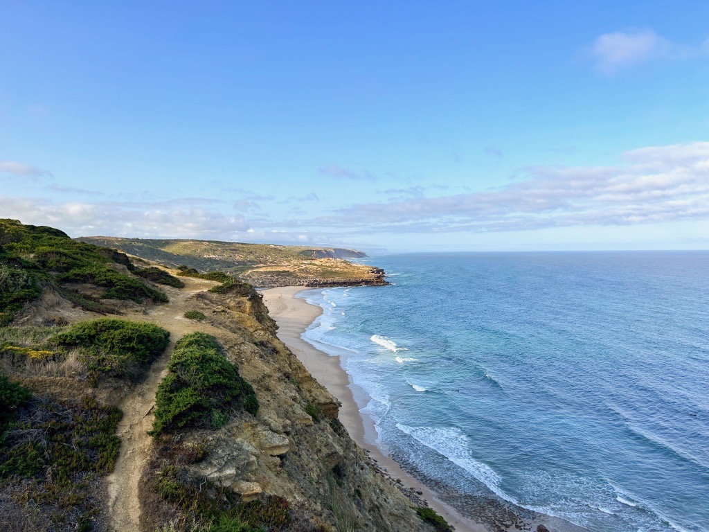 An overhead view of Foz do Lizandro beach and the hiking trails on the cliffs above