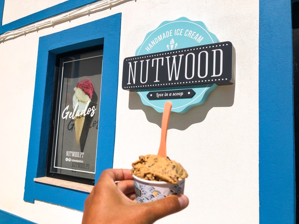 A cup of salted caramel ice cream in front of Nutwood handmade ice cream shop