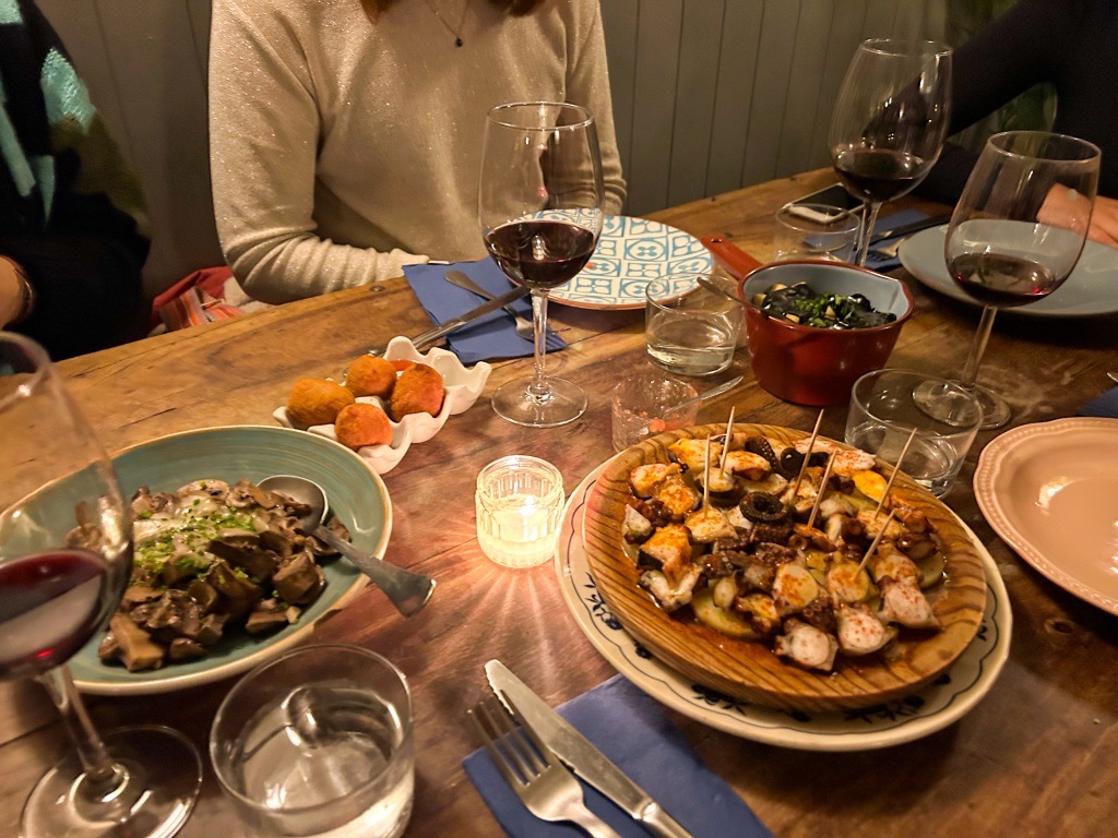 Tapas and glasses of red wine on the table at Popular Restaurant Ericeira